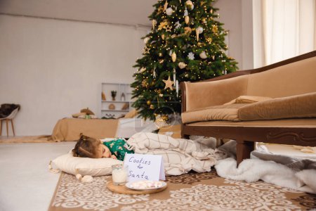 Foto de Linda chica durmiendo en el suelo cerca de las cajas de regalo de Navidad - Imagen libre de derechos