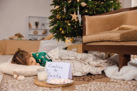 Foto de Linda chica durmiendo en el suelo cerca de las cajas de regalo de Navidad - Imagen libre de derechos