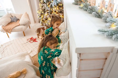 Foto de Gemelos decorando el hogar para Navidad y buscando ocupado - Imagen libre de derechos