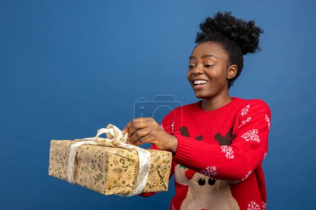 Téléchargez les photos : Joyeux jeune femme tenant des cadeaux chirstmas et regardant excité - en image libre de droit