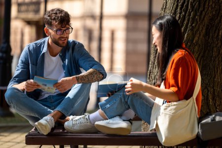 Photo for Studying together. Young people studying outside together and looking involved - Royalty Free Image