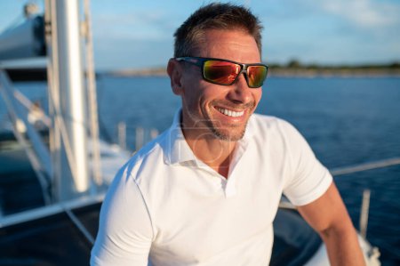 Photo for Man on a yacht. Short-haired confident mature man sailing on a yacht - Royalty Free Image