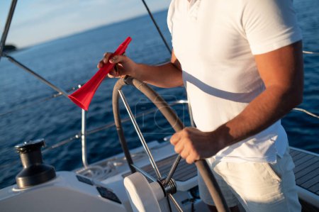 Photo for Man with megaphone. Man in a white tshirt on a yacht with a megaphone in hand - Royalty Free Image