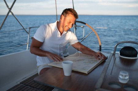 Téléchargez les photos : Un homme sur un yacht. Un bel homme positif sur un yacht se sent bien - en image libre de droit