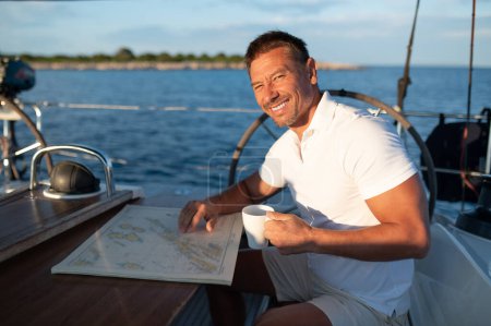 Téléchargez les photos : Un homme sur un yacht. Un bel homme positif sur un yacht se sent bien - en image libre de droit