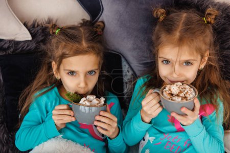 Foto de Dos chicas tomando cacao con crema y luciendo complacidas - Imagen libre de derechos