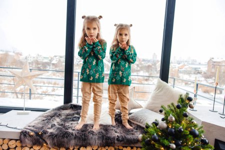 Foto de Dos gemelos jugando y sintiéndose emocionados antes de Navidad - Imagen libre de derechos