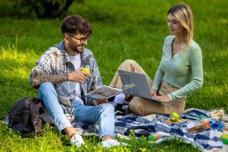 Téléchargez les photos : Avant les examens. Jeunes assis sur l'herbe et se préparant aux examens - en image libre de droit