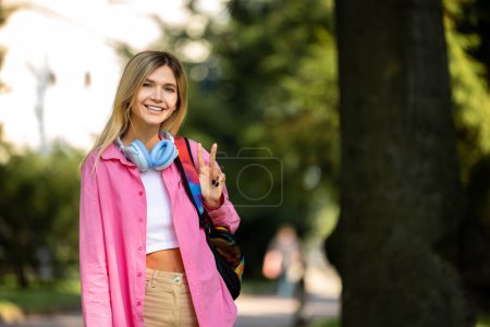 Photo for In the park. Blonde girl in pink jacket in the park - Royalty Free Image