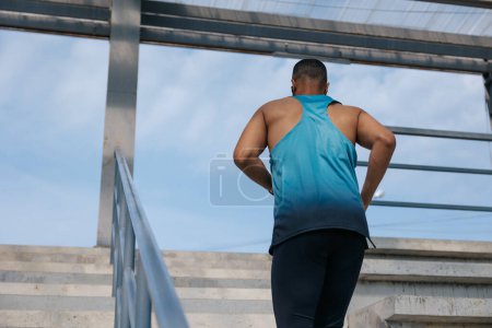 Foto de Corredor. Hombre en camiseta azul corriendo y buscando concentrado - Imagen libre de derechos