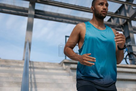 Photo for Runner. Man in blue tshirt running and looking concentrated - Royalty Free Image
