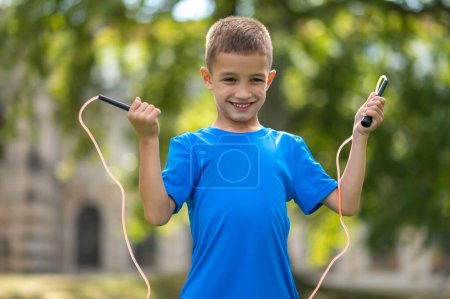 Photo for Jumping. Fair-haired boy with a jumping rope in hands - Royalty Free Image