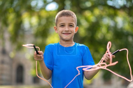 Photo for Jumping. Fair-haired boy with a jumping rope in hands - Royalty Free Image