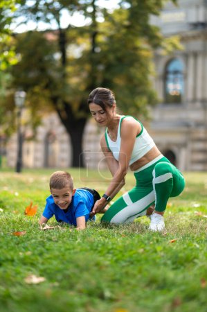 Photo for Workout. Fit woman and her son exercising in the park - Royalty Free Image