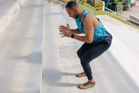 Téléchargez les photos : Des squats. Athlète masculin faisant des exercices de jambes et squats dans les escaliers - en image libre de droit