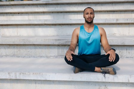 Foto de Yoga. Joven sentado en una pose de loto mientras hace ejercicio - Imagen libre de derechos