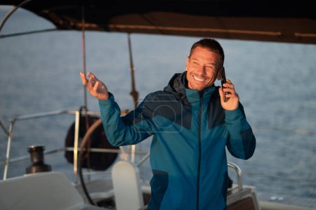 Photo for Man on the phone. Man on the yacht with a cup of coffee talking on the phone - Royalty Free Image