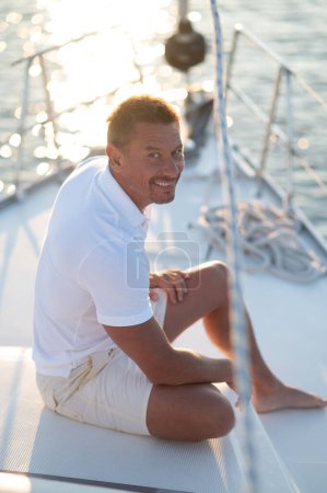 Téléchargez les photos : Voyage. Homme bien construit en t-shirt blanc sur le yacht - en image libre de droit