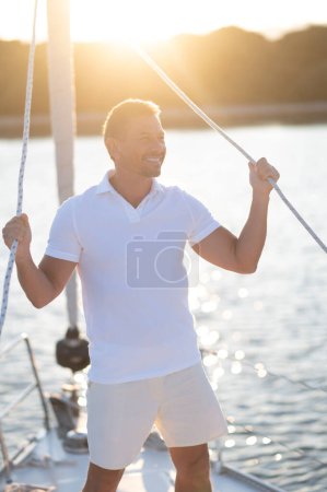 Photo for Journey. Well-built man in white tshirt on the yacht - Royalty Free Image