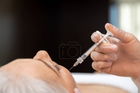 Photo for At beauty clinic. Mature woman receiving anti age teatment at beauty clinic - Royalty Free Image