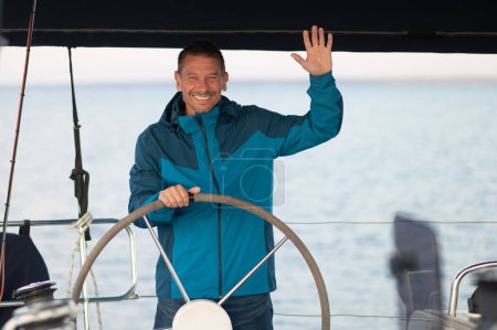 Photo for Captain. Smiling mature man sailing a ship - Royalty Free Image