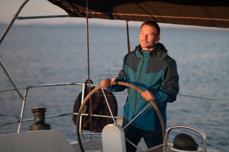 Téléchargez les photos : Un homme sur un yacht. Homme mûr debout près de la direction whell sur le yacht - en image libre de droit