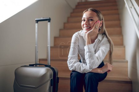 Téléchargez les photos : Dans les escaliers. Jeune femme avec une valise dans les escaliers - en image libre de droit