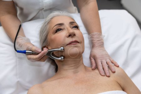Photo for Micro current therapy. Mature woman having micro current therapy at beauty clinic - Royalty Free Image