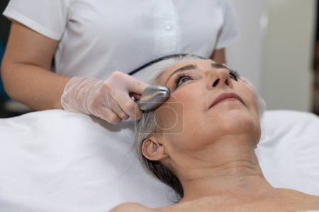 Photo for Micro current therapy. Mature woman having micro current therapy at beauty clinic - Royalty Free Image