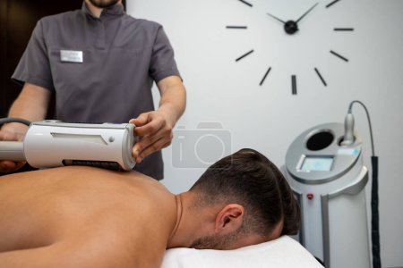 Photo for Rehabilitation center. Young man having rehabilitation procedures in a clinic - Royalty Free Image