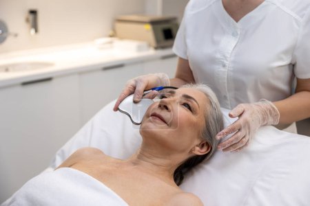 Photo for Beauty care. Mature woman having beauty procedure at cosmetological clinic - Royalty Free Image