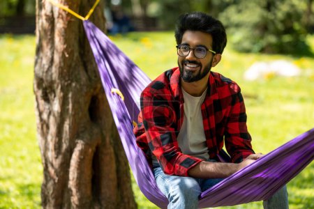 Photo for Young hindu man feeling relaxed and happy in the park - Royalty Free Image