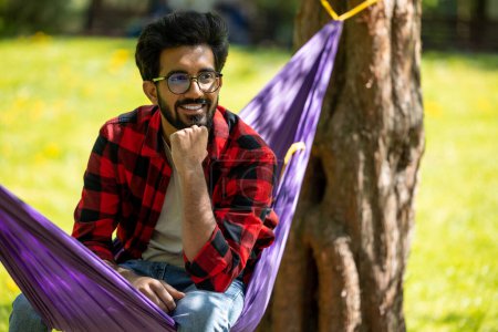 Foto de Joven hombre hindú sentirse relajado y feliz en el parque - Imagen libre de derechos