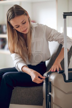 Photo for Young female wearing stylish clothing guest or new tenant with luggage suitcase. - Royalty Free Image
