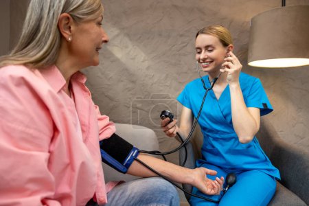 Téléchargez les photos : Infirmière ou médecin vérifiant la pression artérielle chez une femme âgée dans un centre de soins médicaux. - en image libre de droit