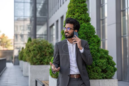 Photo for Dark-haired hindu businessman working outside and having a phone call - Royalty Free Image