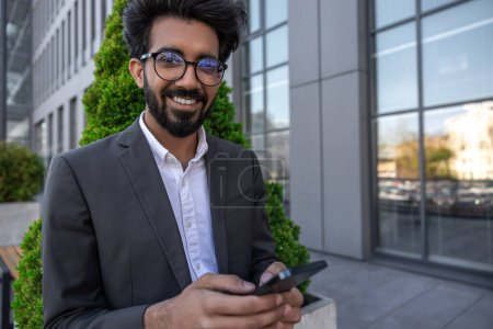 Photo for Bearded smiling handsome hindu businessman with a phone in hands - Royalty Free Image