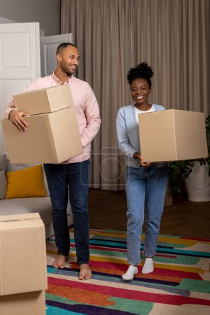 Téléchargez les photos : Satisfait homme et femme maison propriétaire tenant boîte en carton déménageant dans un nouvel appartement - en image libre de droit