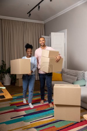 Photo for New marriage couple moving to new house together holding boxes parcel enjoying relocation - Royalty Free Image