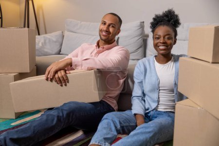Téléchargez les photos : Nouveau couple de mariage déménageant dans une nouvelle maison ensemble tenant des boîtes colis bénéficiant d'une réinstallation - en image libre de droit