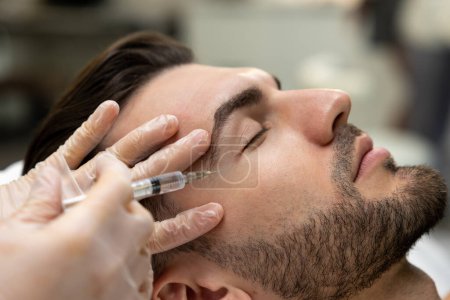 Photo for Mesotherapy. Dark-haired bearded man having session of mesotherapy in a beauty salon - Royalty Free Image