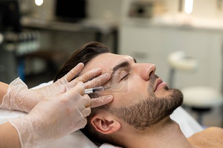 Photo for Mesotherapy. Dark-haired bearded man having session of mesotherapy in a beauty salon - Royalty Free Image