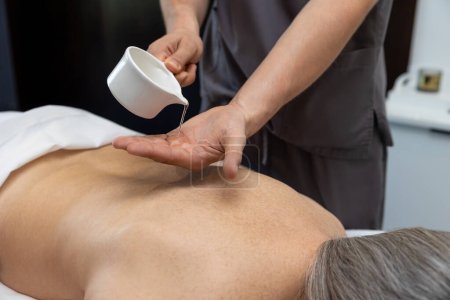Téléchargez les photos : Massage du dos. Gros plan d'une patiente qui se fait masser le dos dans une clinique - en image libre de droit