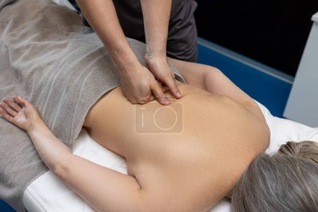Foto de Masaje de espalda. Primer plano de la paciente femenina que recibe masaje de espalda en una clínica - Imagen libre de derechos