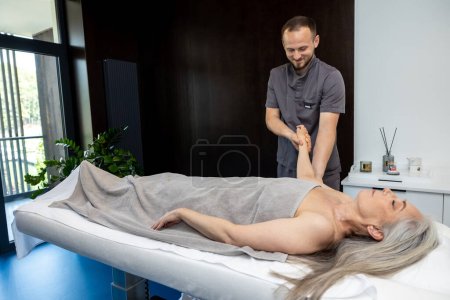 Téléchargez les photos : Massage des mains. Masculin massothérapeute faisant massage des mains à une cliente - en image libre de droit
