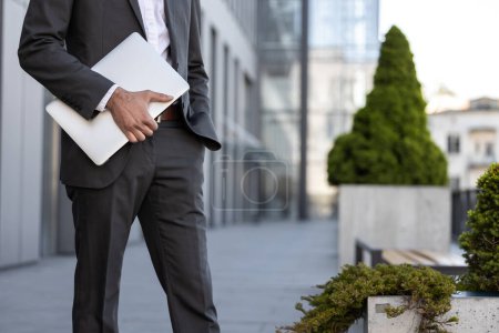 Photo for Close up of elegant man with a laptop in hands walking - Royalty Free Image