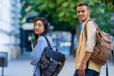 Foto de Dos estudiantes internacionales caminando cerca del campus y sonriendo. - Imagen libre de derechos