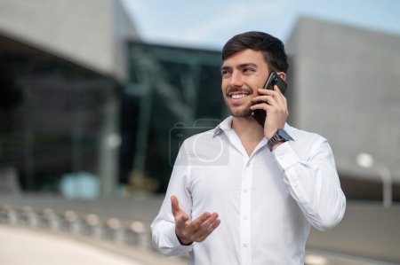 Photo for Phone call. Dark-haired young man talking on the phone - Royalty Free Image