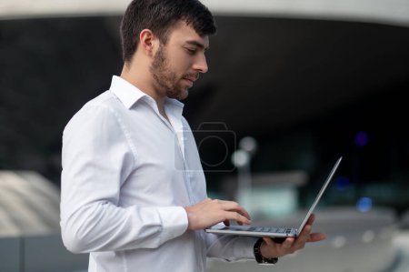 Téléchargez les photos : Travail à distance. Homme d'affaires avec un ordinateur portable travaillant à l'extérieur - en image libre de droit