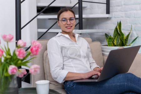 Photo for Woman freelancer in glasses working online in home interior. - Royalty Free Image